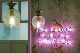 Charming kitsch such as pineapple-shaped lighting and wall-mounted neon adds a note of friendly whimsy.