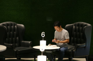 A first-class lounge with high-back wine chairs and turf-like grass caters to high-value customers.
