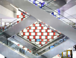 The colourful chequerboard backdrop to the escalators provides a connection between the floors in Shinsegae's luxury department store