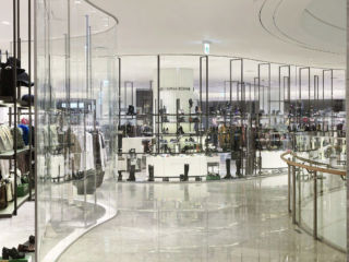 A sculptural, curvaceous glass wall leads customers through the designer womenswear department at The Hyundai
