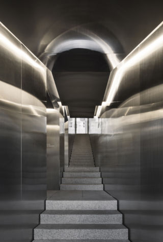 A stainless steel stairwell evokes an HVAC tunnel.