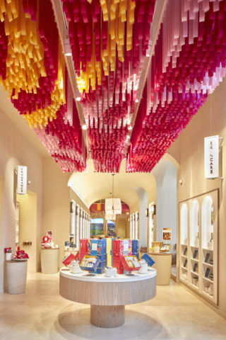 A vivid ceiling installation references the marketplaces of Provençal.