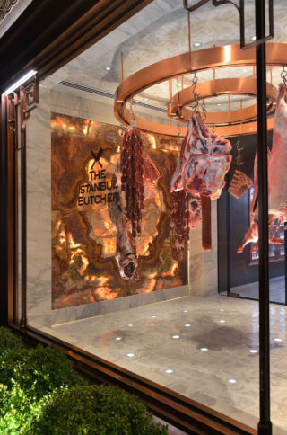 A coolroom features two circular copper racks for drying meat.