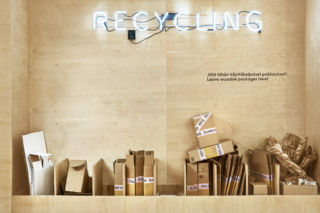Reducing packaging waste and recycling is central to the concept. Posti estimates that 10% of a T-shirt’s emissions come from transporting a package home so they enable unpacking and repacking on-site.